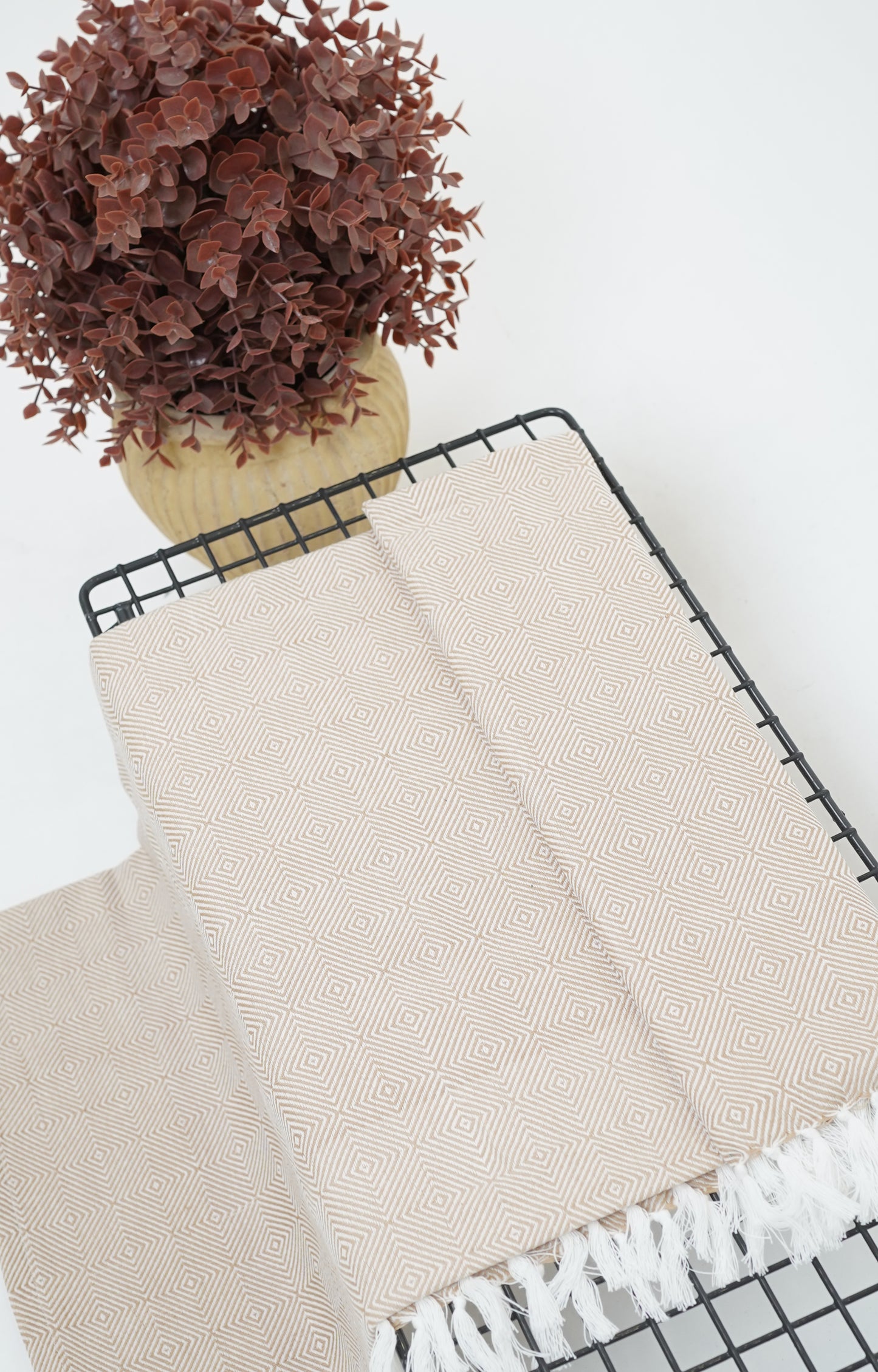 white Chennimalai soft Diamond weave towel Half with white fringe on a black metal rack against a white background