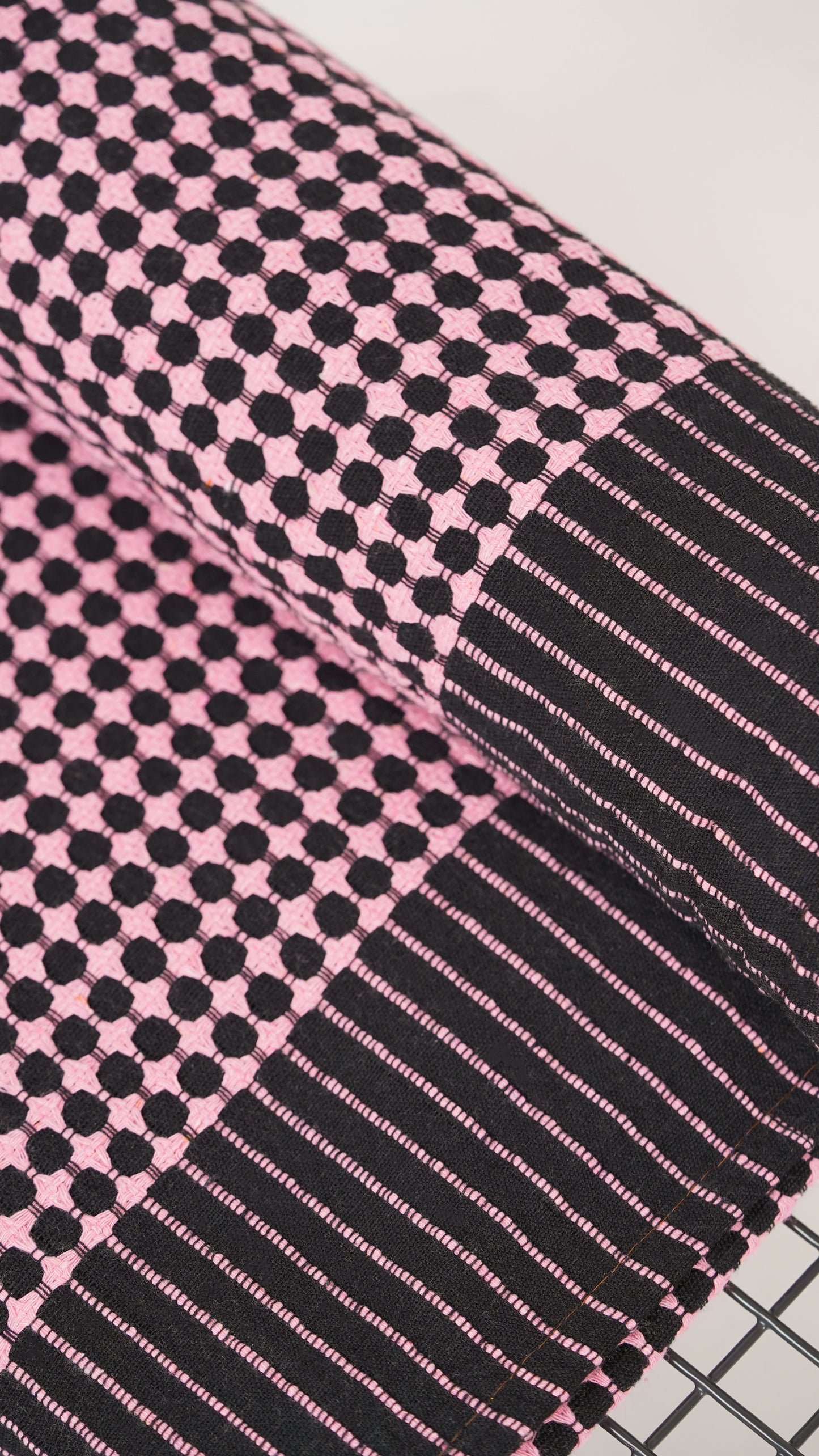 Close-up of a pink and black checkered fabric with stripes.