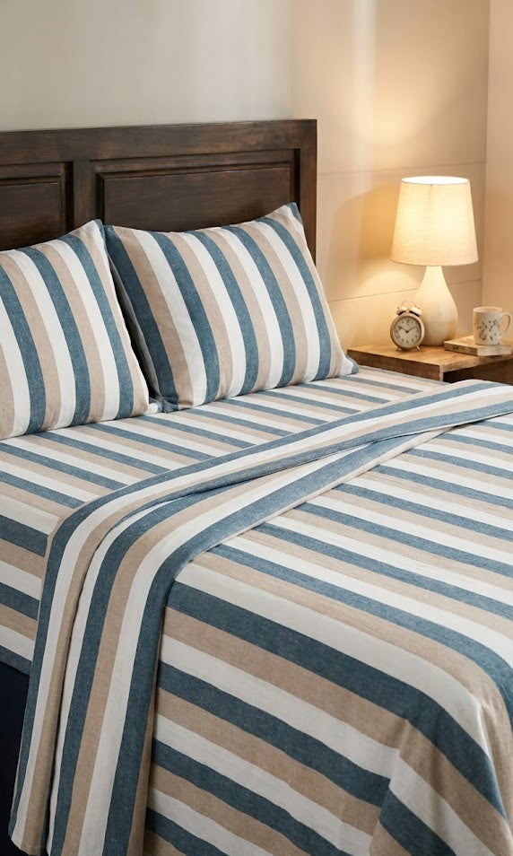 Double Cot Chennimalai Bedspread Soft Teal Stripe on a bed with a wooden headboard and lamp in the background.