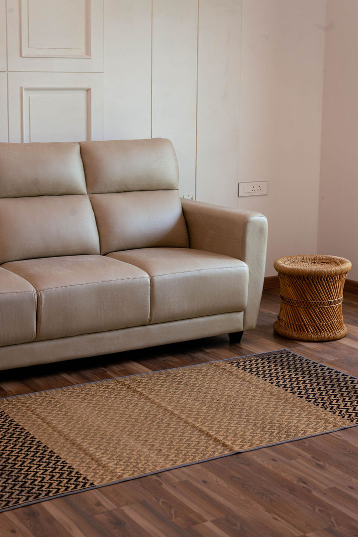 Beige sofa in a room with wooden flooring and a woven side table.