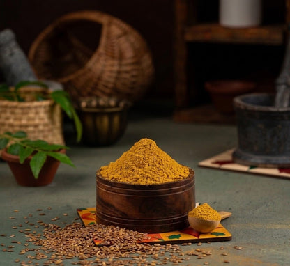 Wooden bowl filled with Azhli Vidhai Menas (Flax Seeds Podi) on a textured surface with seeds around