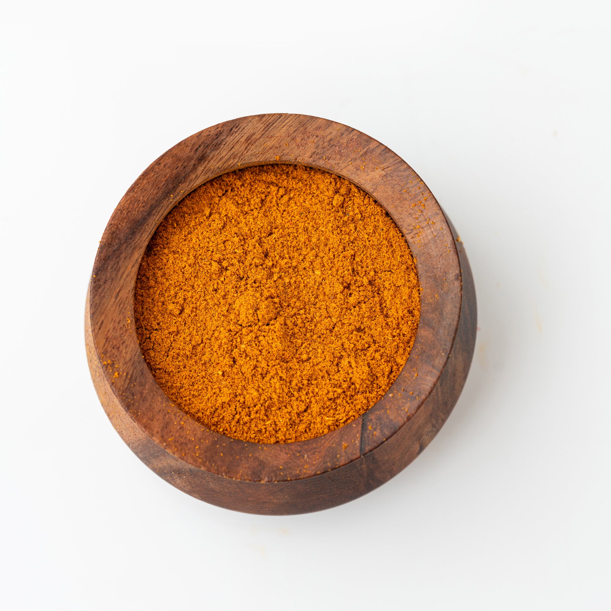 Wooden bowl filled with Azhli Vidhai Menas (Flax Seeds Podi) on a white background