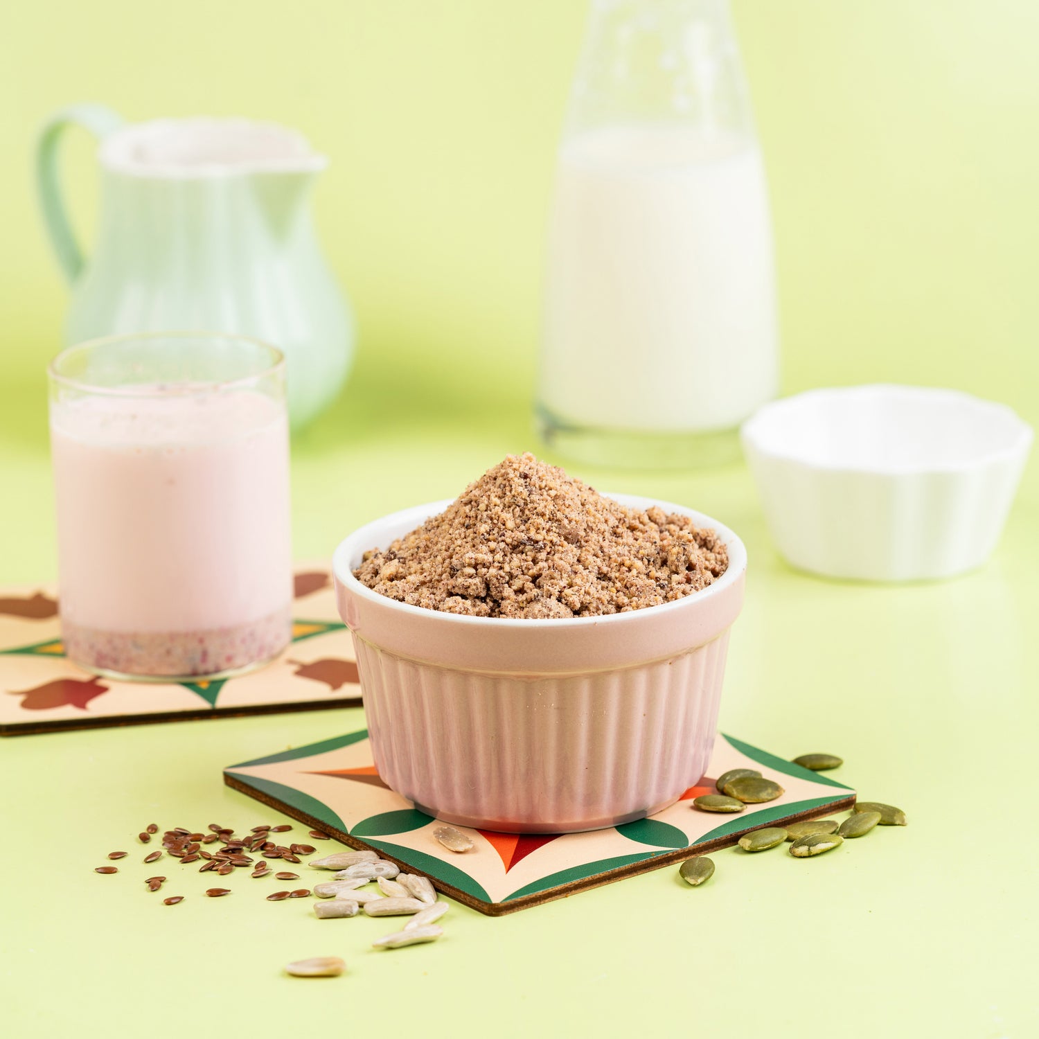 A bowl of Biotin Powder is presented with a glass and a carafe filled with milk in the background, suggesting usage as a supplement to be mixed with milk.