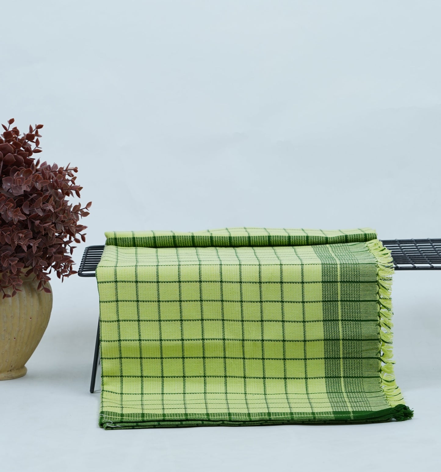 Chennimalai Soft Grid Weave Towel Lime Green on a table with a light blue background
