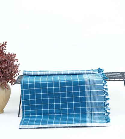 Chennimalai Soft Grid Weave Towel (Teal) on a metal rack with a plant in the background
