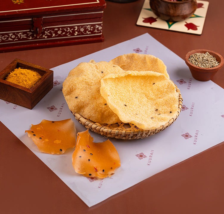 Sun-dried spicy snack served on a basket with spices in the background, presented on a table with a decorative cloth.