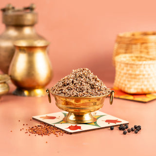 A bowl of air fried millet spicy (ragi) placed on a colorful square plate, with a backdrop of bronze-colored containers and woven baskets.