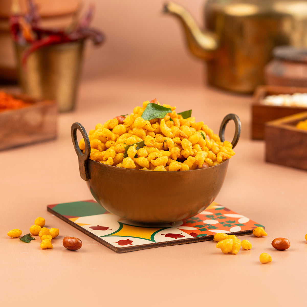 A bowl of kaara boondhi, also known as crispy gram flour balls, presented on a table with a patterned napkin underneath.
