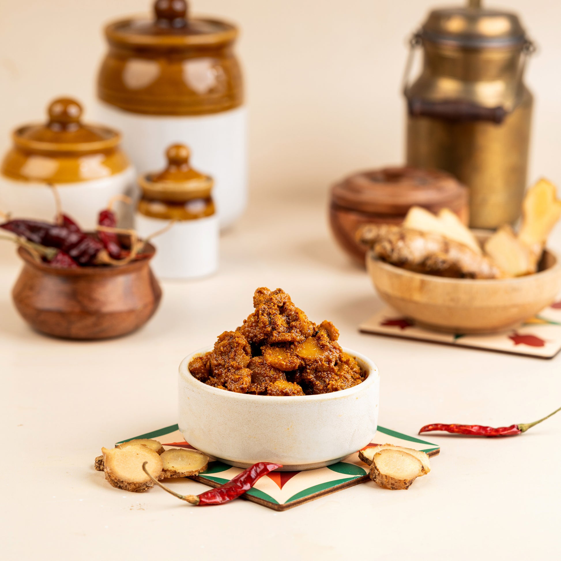 A bowl of Ma Inji (Mango Ginger) Pickle in the foreground with blurred background elements suggesting a traditional pickle shop setting.