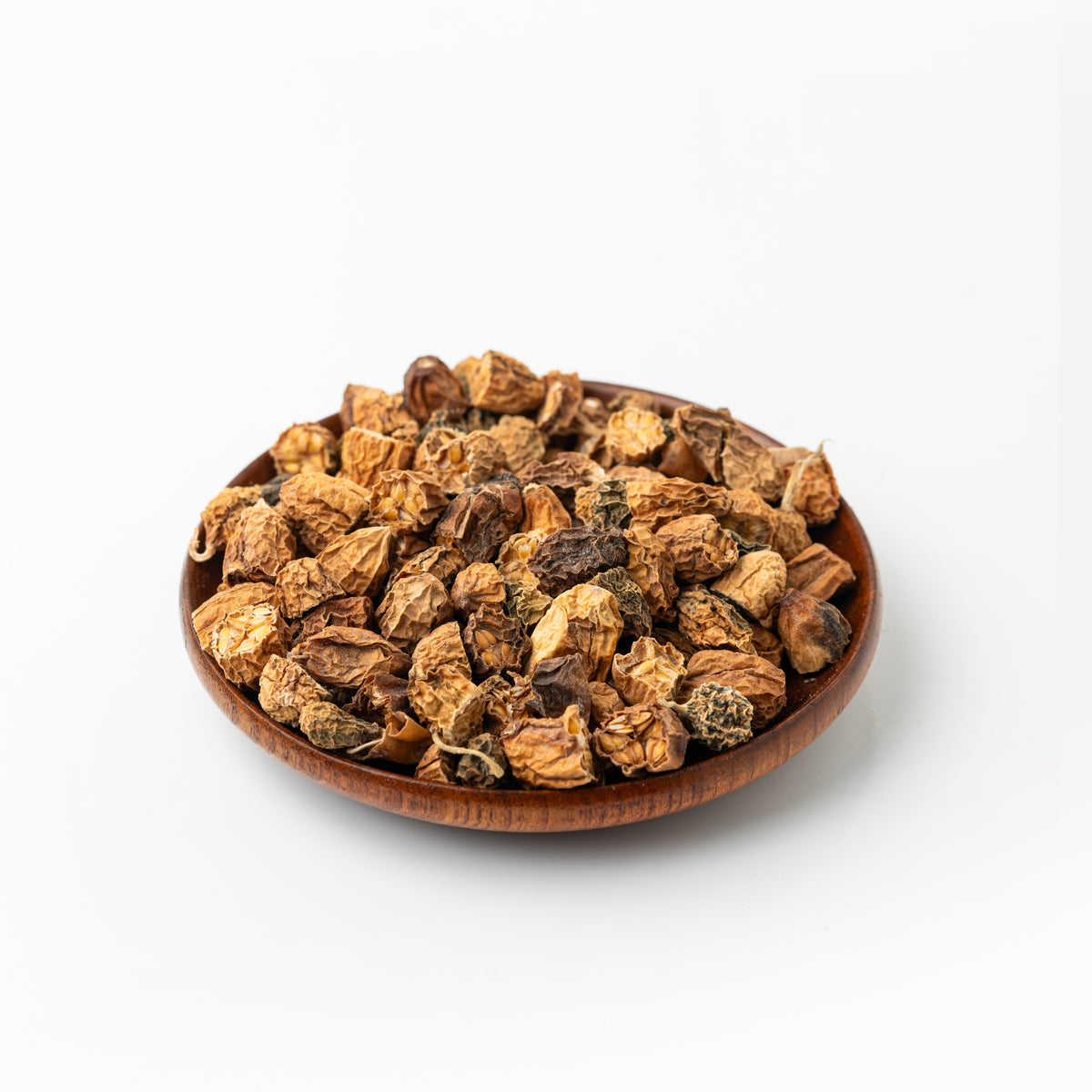 Wooden bowl filled with dried herbs on a white background
