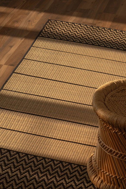 Grass mat with zigzag border on wooden floor next to a woven basket