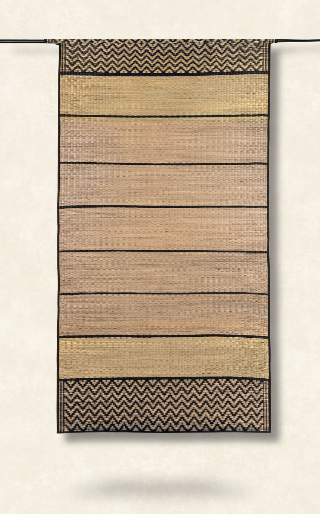 Woven grass mat with striped pattern on a plain background