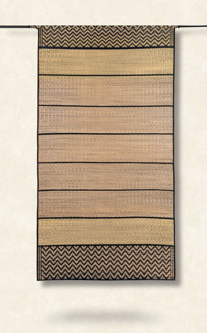 Woven grass mat with striped pattern on a plain background