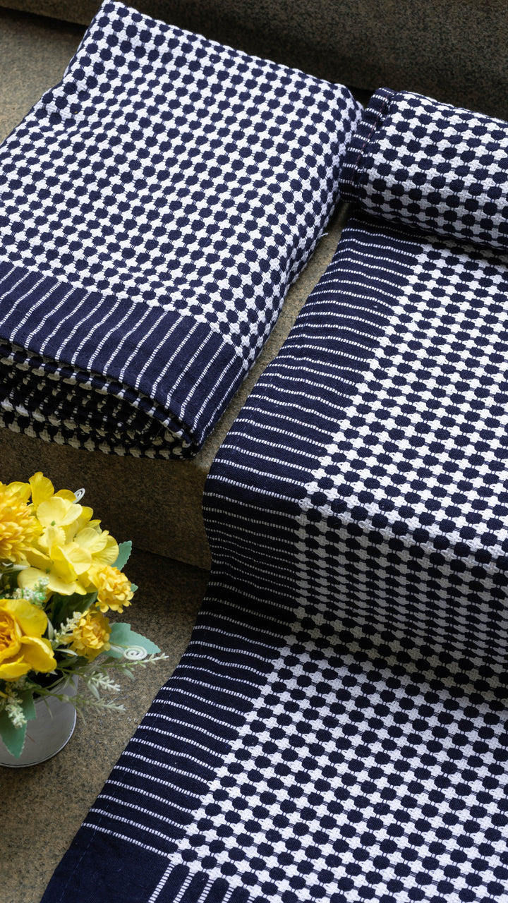 Navy and white checkered fabric on a surface with yellow flowers in the background