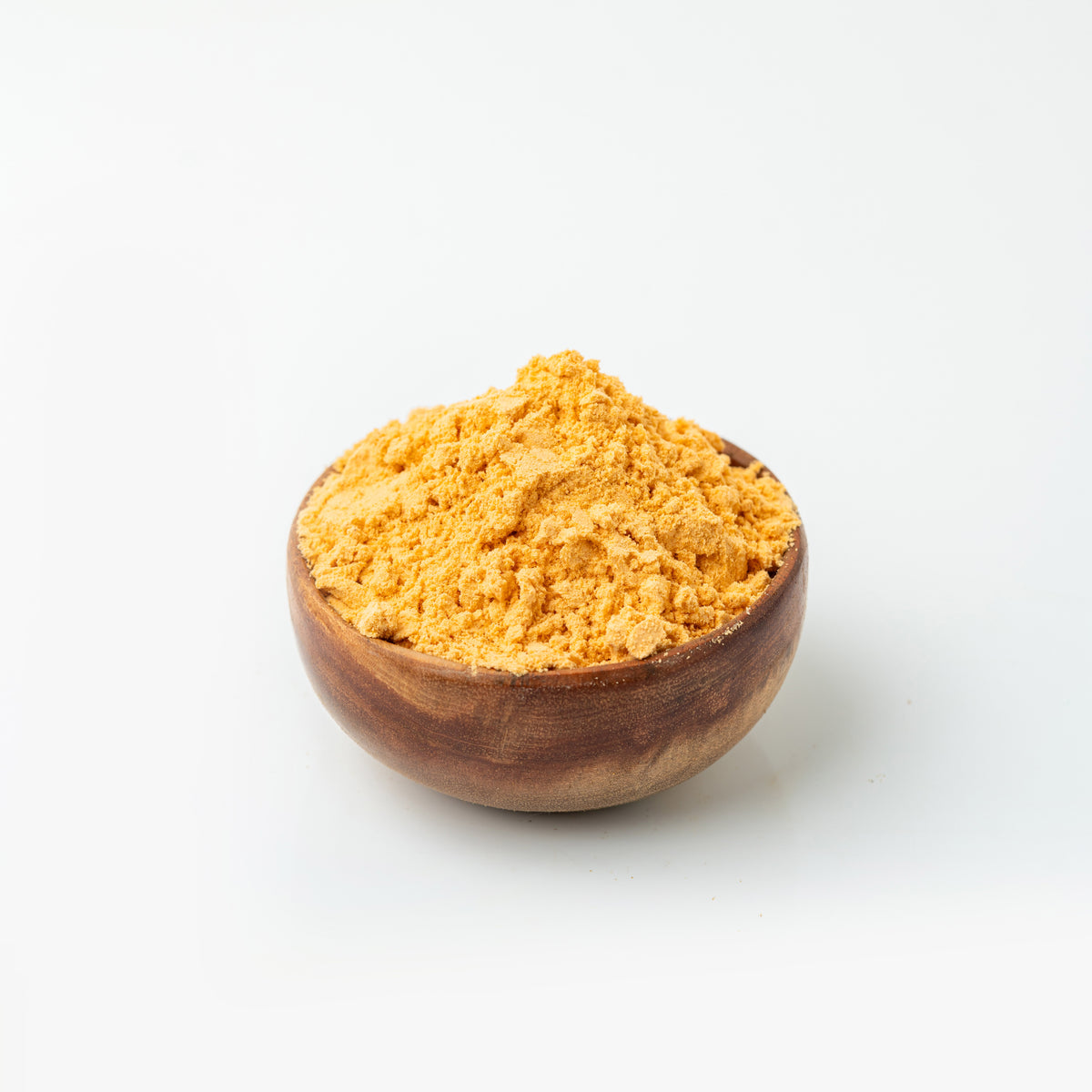 Wooden bowl filled with Nellikai Podi (Amla Powder) on a white background