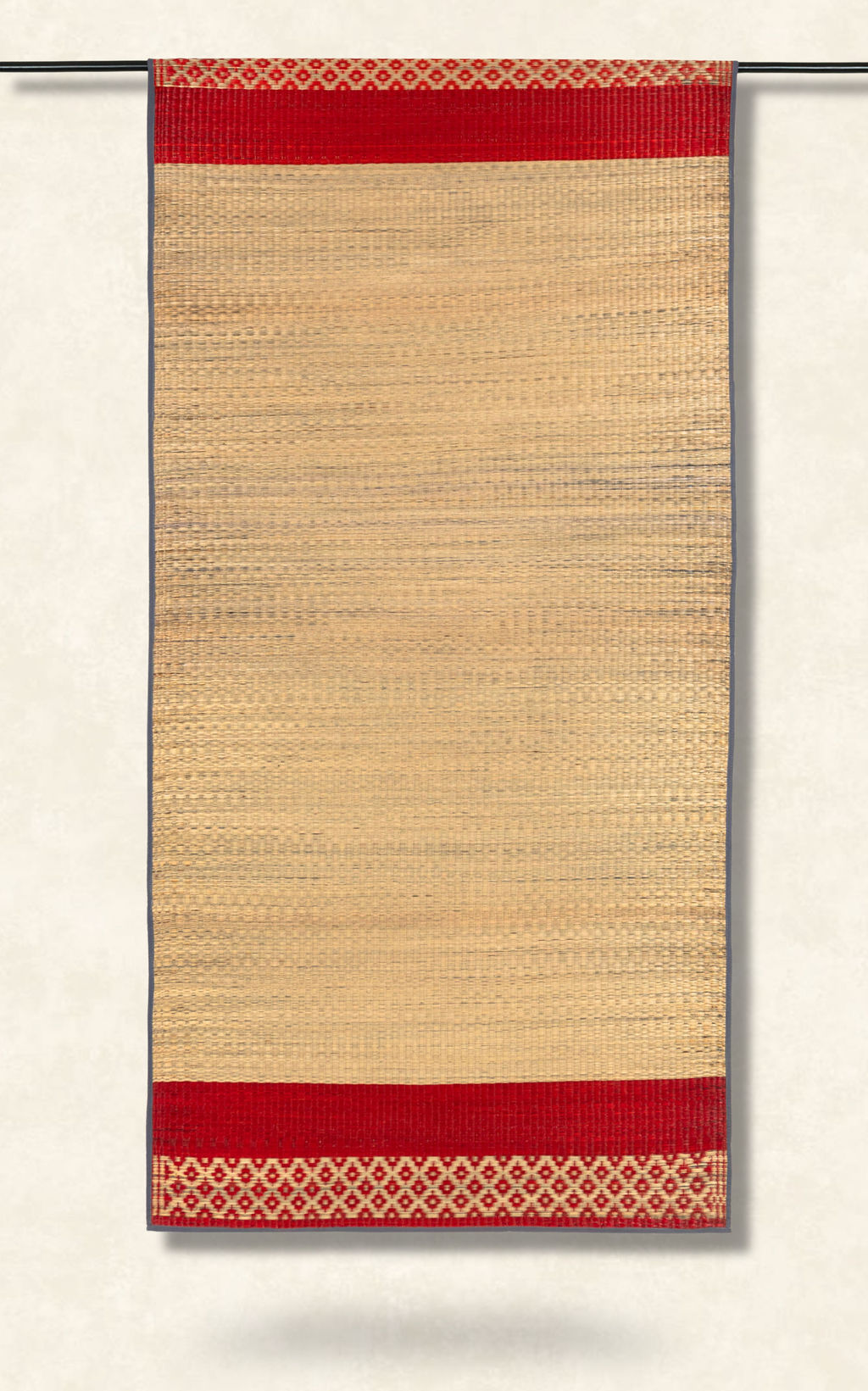 Beige woven rug with red border and geometric pattern on a white background