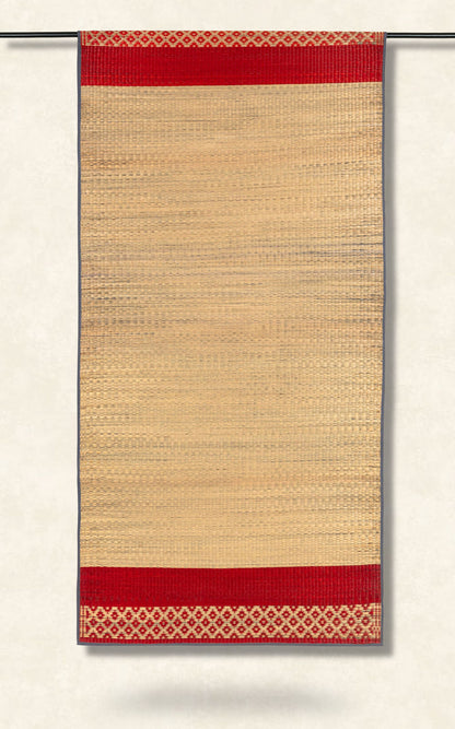 Beige woven rug with red border and geometric pattern on a white background