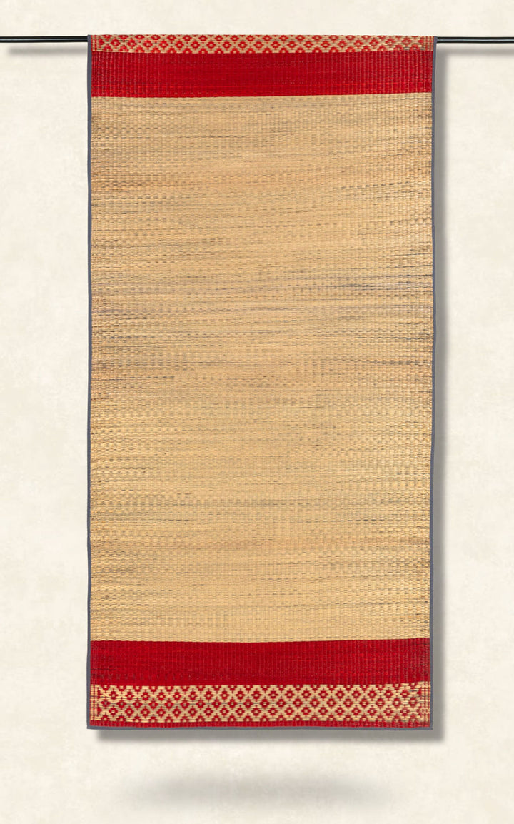 Beige woven rug with red border and geometric pattern on a white background