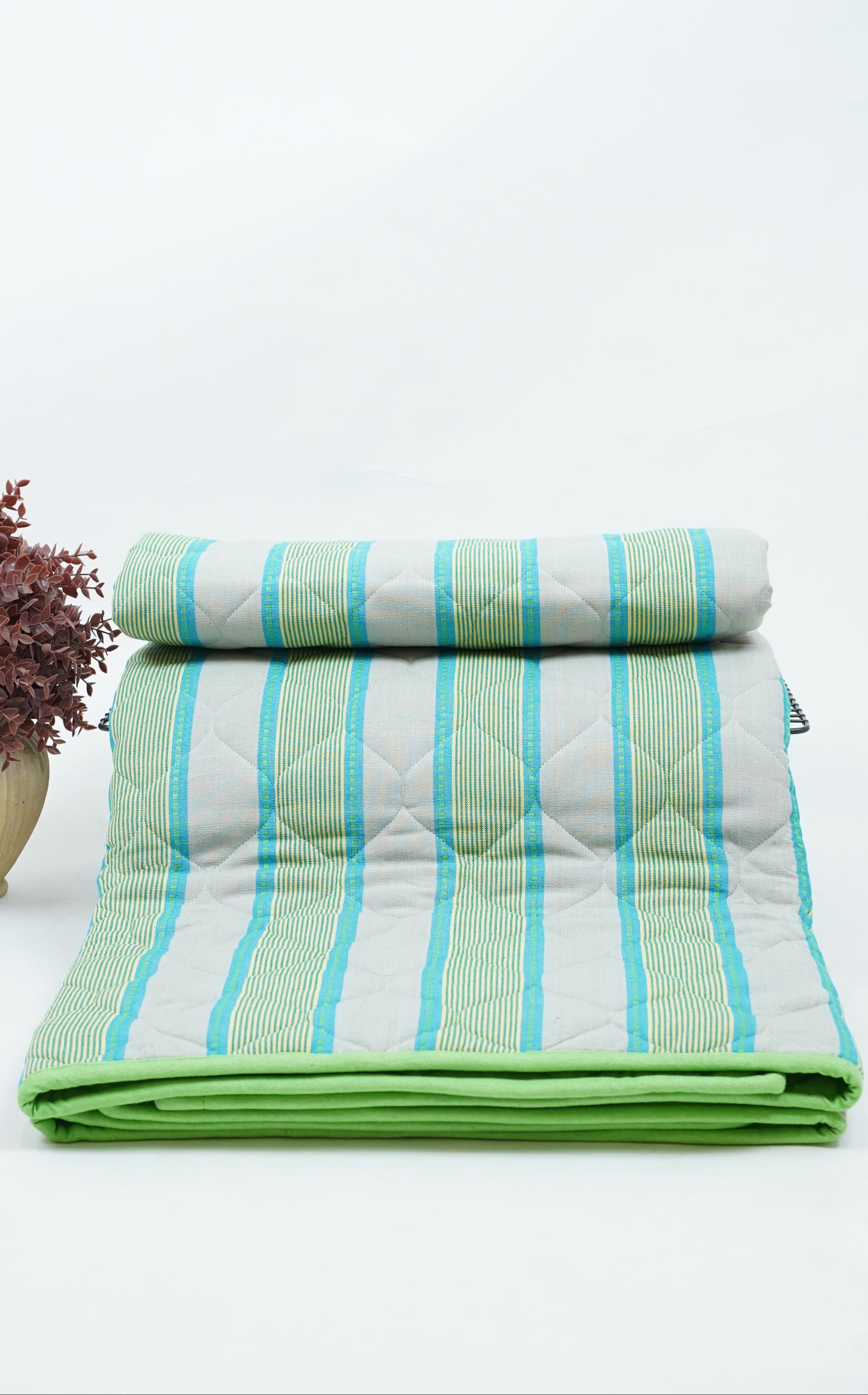 Folded green and white striped Premium Handloom Single Cot Chennimalai Quilt on a light gray background