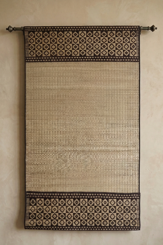 Sadhuram Pattamadai pai hanging with geometric patterns on a beige wall