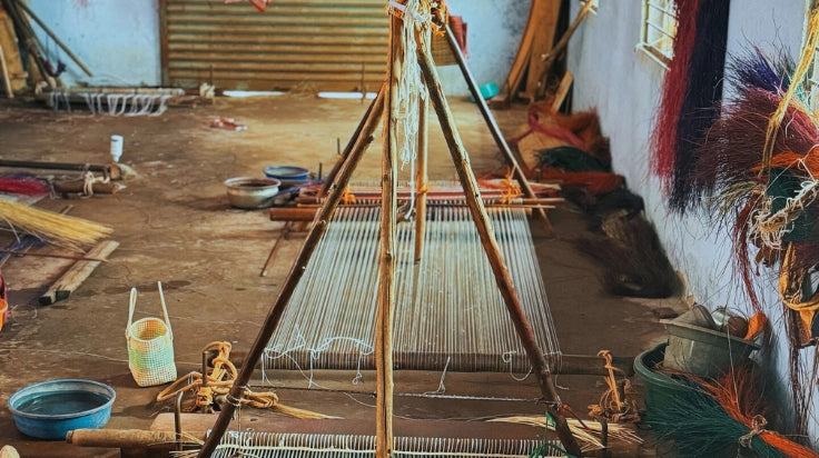 Weaving loom in a workshop with various tools and materials.