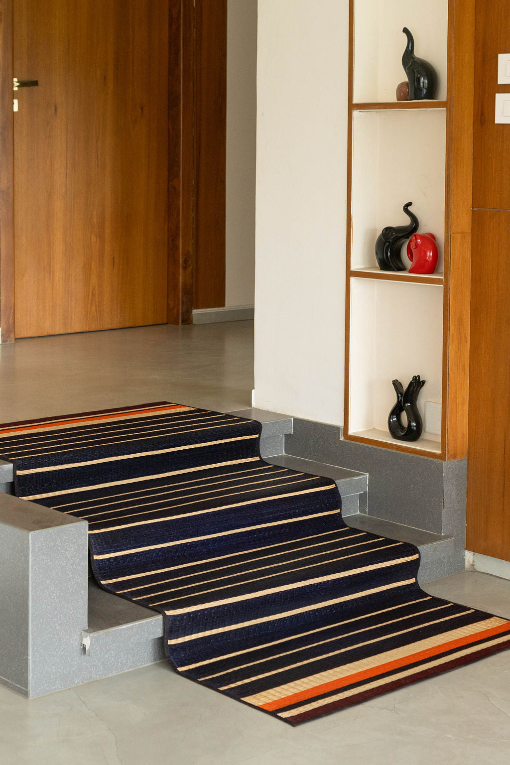 Staircase with a striped rug in a home setting
