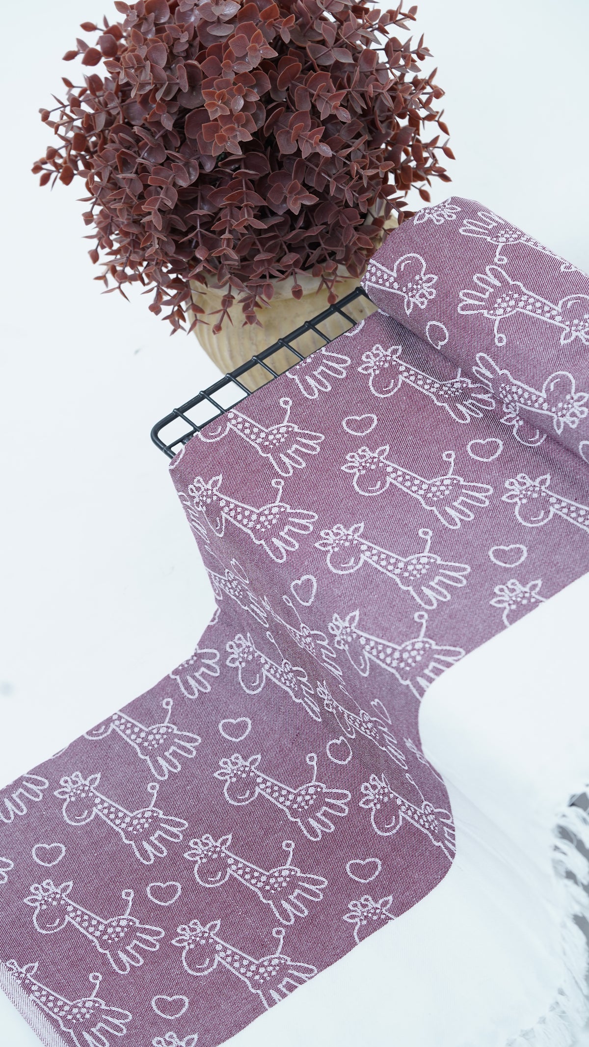 Purple bedsheet with white animal pattern on a white surface