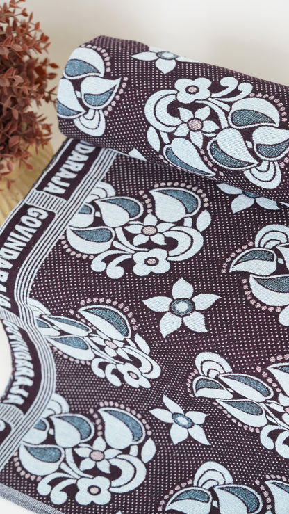 Floral patterned fabric with white flowers on a brown background