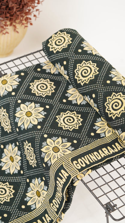 G. Raja Chennimalai Bed Sheet with gold floral patterns on a metal cooling rack