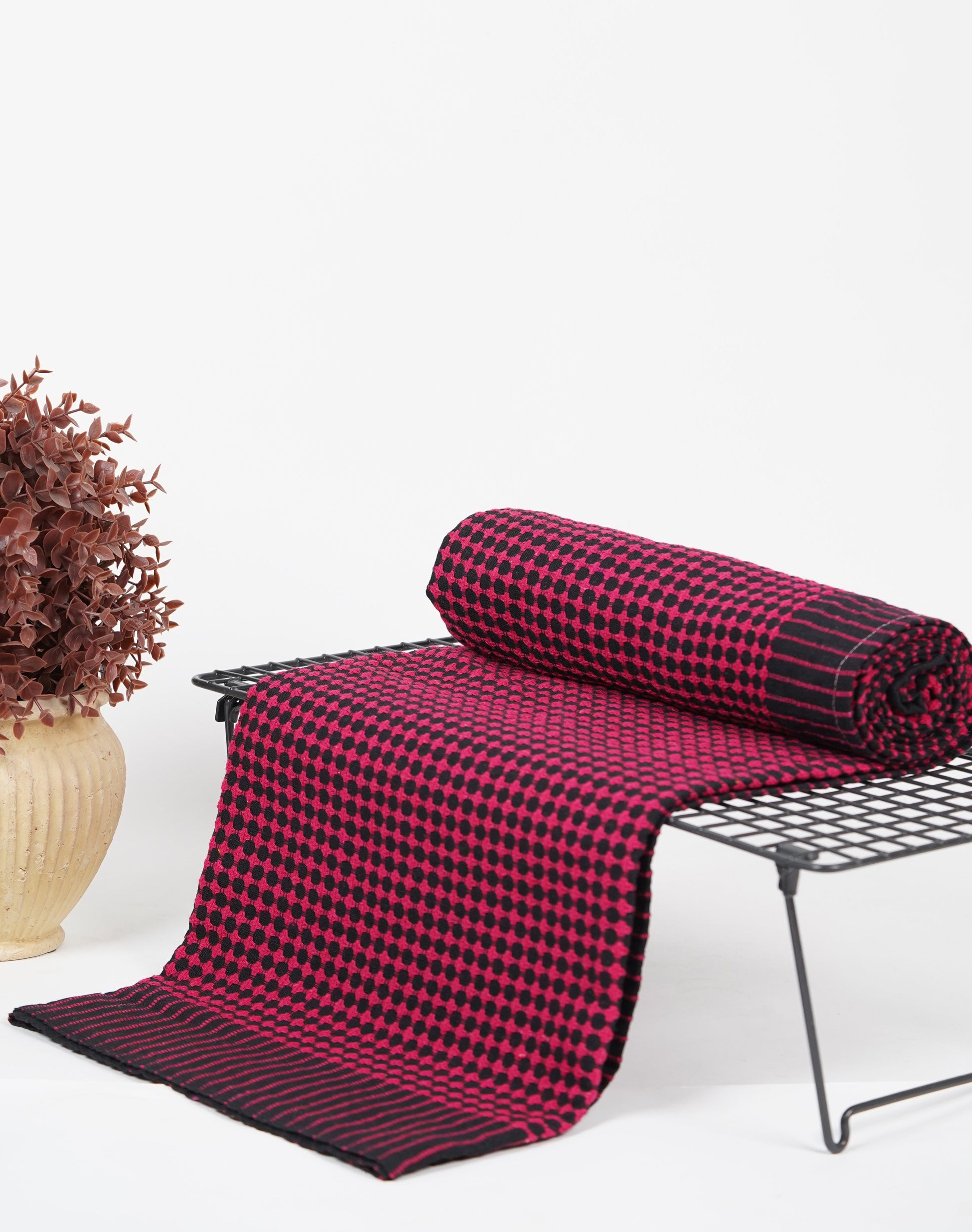 Red and black checkered blanket on a chair with a white background