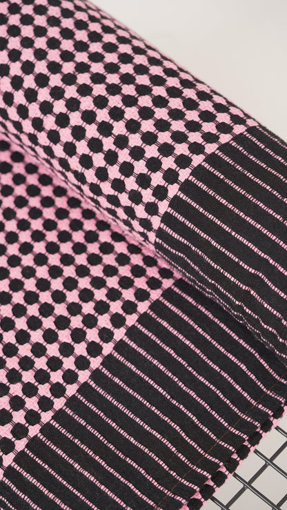 Close-up of a pink and black checkered fabric with stripes.