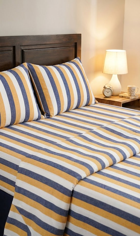 Chennimalai Double Cot Bedspread Coastal Stripe on a bed with pillows and a lamp in the background